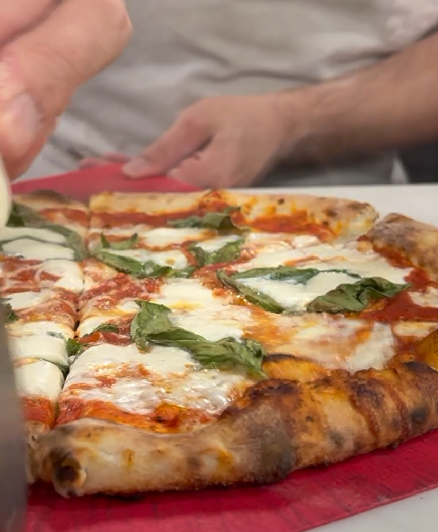 Close up photo of person cutting pizza